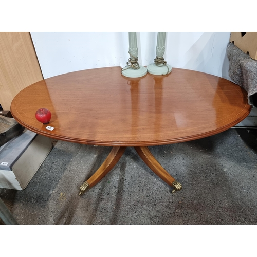 937 - A gorgeous oval coffee table with lovely string inlay to top, held on a central pillar with splayed ... 