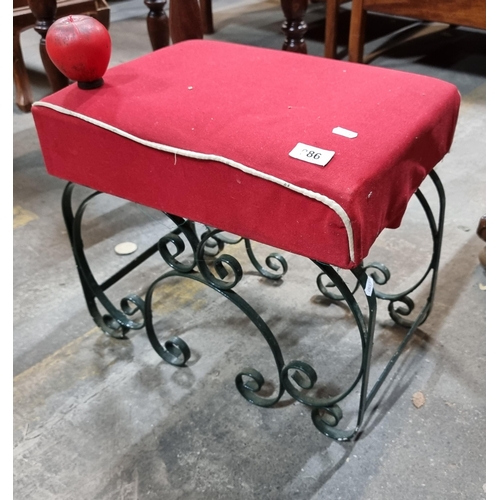 986 - An unusual vintage footstool with wrought metal supports featuring curvilinear motifs. With padded r... 