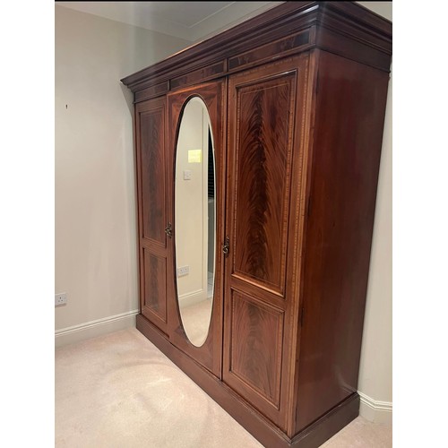 704 - Star Lot: A magnificent antique Edwardian mahogany wardrobe with large beveled oval mirror to centre... 