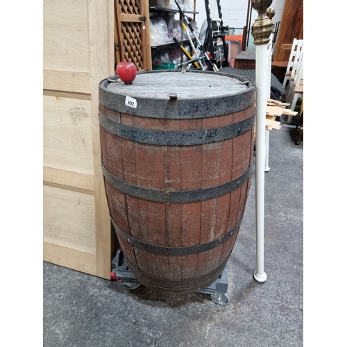 A large heavy vintage barrel with metal banding. H89cm x D70cm