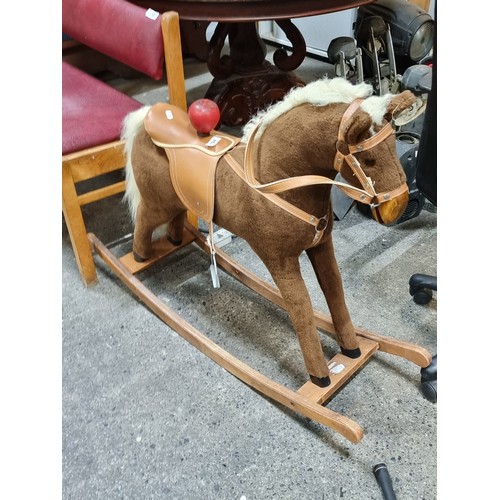 794 - A charming children's rocking horse with reigns and saddle and stirrups. Set on wooden rockers.