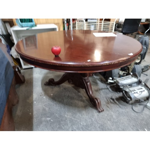 798 - A stunning large antique round mahogany dining table, held on a central pillar splaying into three l... 