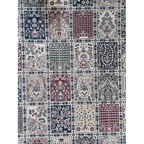 945 - A fabulous woolen rug featuring an intricate foliate and geometric pattern in shades of beige, red a... 