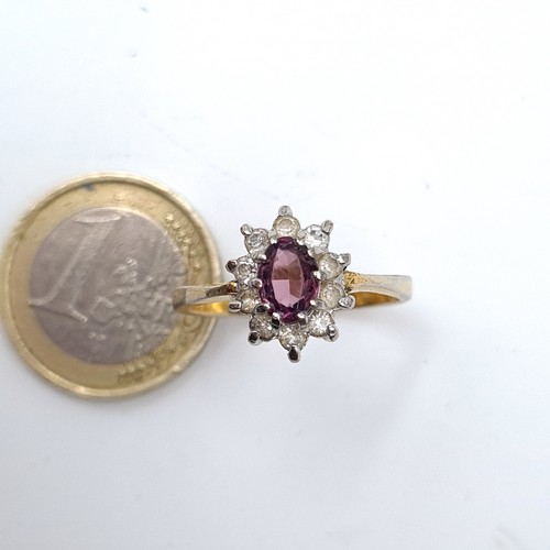 895 - A lovely 9k gold gem set ring with a purple central stone with a cluster surround, stamped 