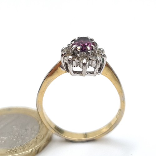 895 - A lovely 9k gold gem set ring with a purple central stone with a cluster surround, stamped 