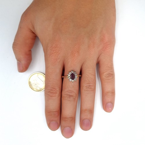 895 - A lovely 9k gold gem set ring with a purple central stone with a cluster surround, stamped 