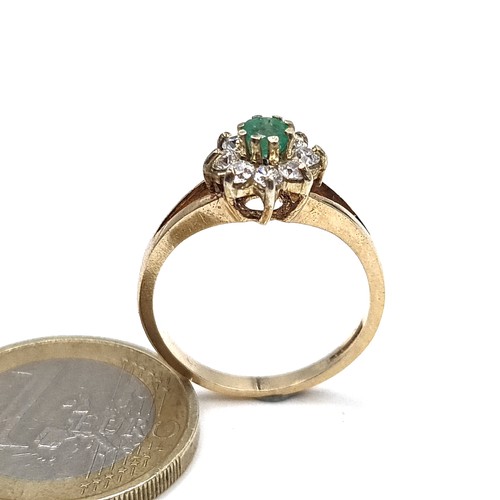 951 - Star lot : A 9K gold ring with a raised mount featuring an emerald with a gem set floral cluster, ri... 