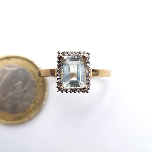 955 - Star Lot : A 9K gold ring with an aqua marine stone and a diamond surround, ring size Q, weight 2.64... 