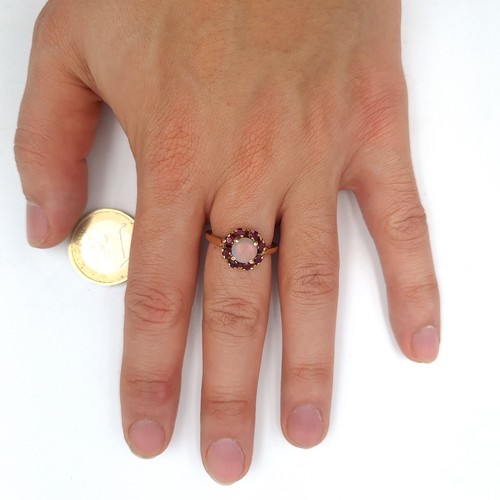 561 - Star Lot : A vintage opal stone ring with a ruby cluster surround mounted on 14K gold (stamped to ba... 