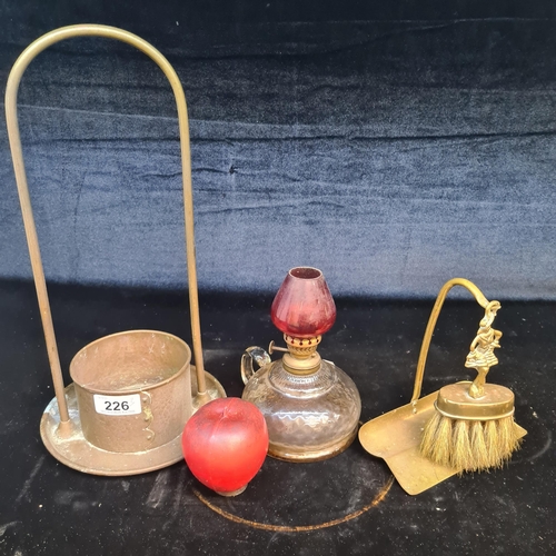 226 - Three vintage collectable household items including a large brass candle holder, a thumb oil lamp wi... 