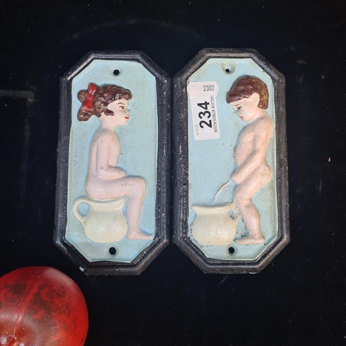 234 - A pair of cast metal toilet door plaques with designs in relief.