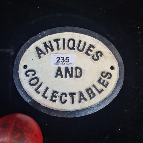 235 - An oval cast metal plaque reading 'Antiques and Collectables'.