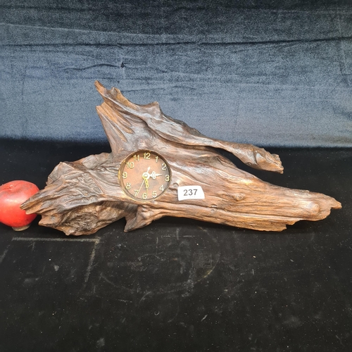 237 - A rustic drift wood desk clock boasting an organic form and brass features. With stand to back.