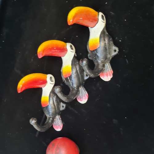 240 - A set of three cast metal coat hooks in the form of toucans.