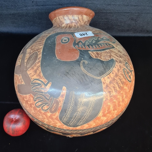 248 - A very heavy large handmade clay pot of Mexican origin featuring a hand incised Toucan bird. Signed ... 