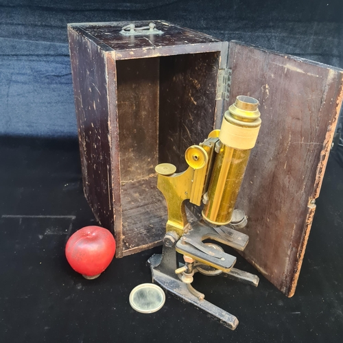 249 - A vintage brass microscope complete with a heavy base and original wooden box.