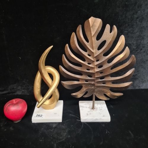 262 - Two striking abstract sculptures featuring a stylized leaf and knot design Both on white marble base... 