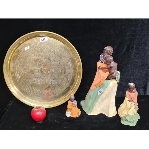 329 - An intricate brass tray, featuring detailed etchings along with a collection of African figurines, c... 