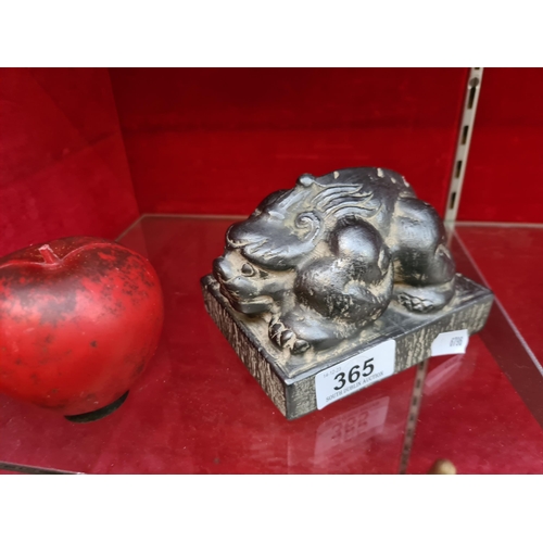 365 - An elegant antique cast metal Chinese style figure of a crouching lion, with wonderfully stylised fe... 