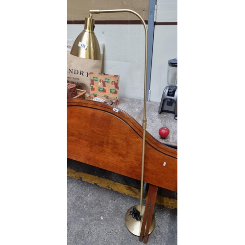 432 - A contemporary brass floor standing reading lamp with slim arched stem and round base. H150cm