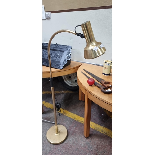 438 - A stylish brass floor standing reading lamp with arched stem and round base. H130cm