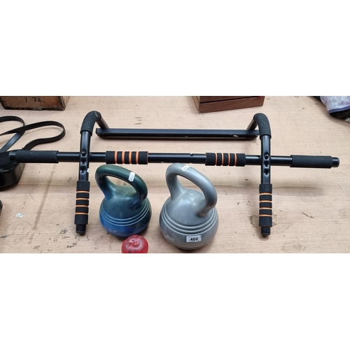 460 - Three pieces of exercise equipment including two kettle bells and a pull up bar.