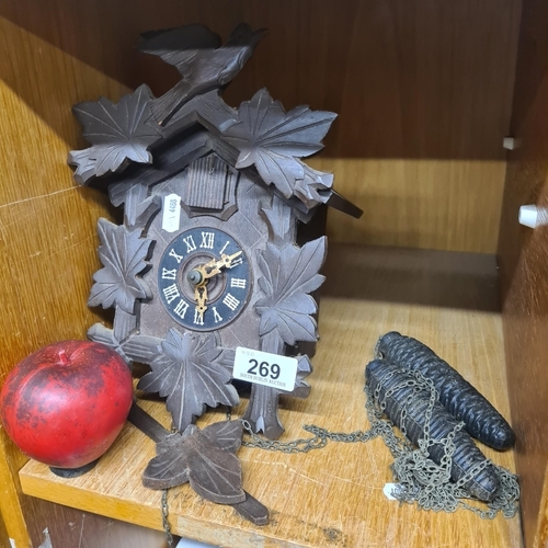 269 - A vintage carved cuckoo clock, showcasing meticulous craftsmanship in wood, complete with accompanyi... 