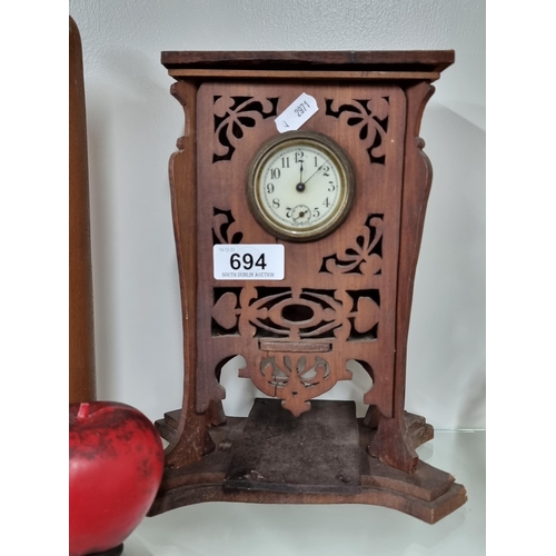 694 - A charming vintage USA made mantle clock with glass and enamelled face. Housed in an unusual carved ... 