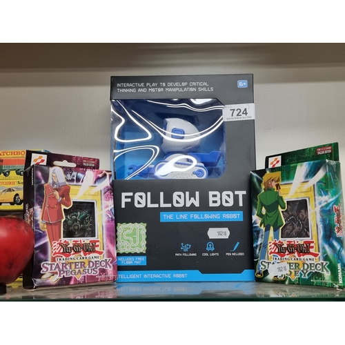 724 - Three brand new items including Follow Bot with floor mat accompanied by two Yu-Gi-Oh playing card p... 