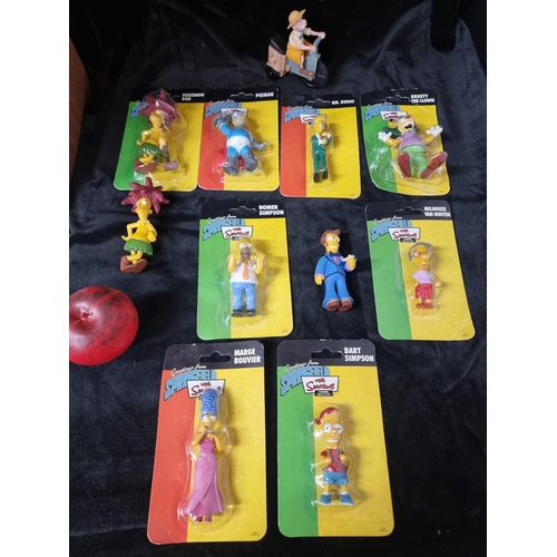 734 - A collection of 11 collectable figurines including The Simpsons characters with Homer, Marge, Bart, ... 