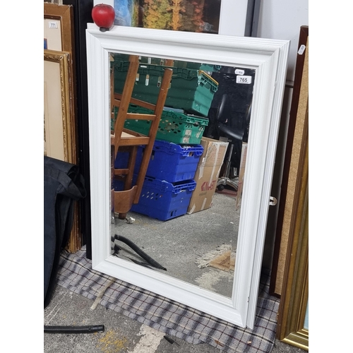 765 - A handsome wall mirror with beveled glass, held in a fresh white wooden frame. 
MM: W66 x H91 cm