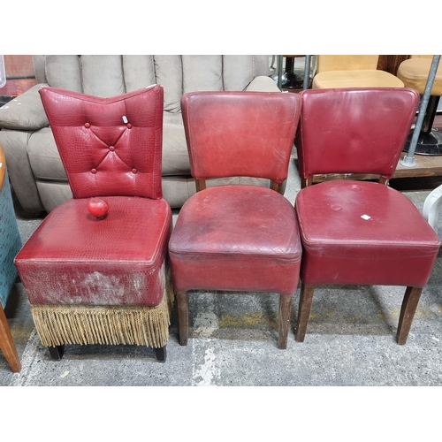 636 - Three commercial vinyl red leather chairs. One featuring button back with flamboyant gold fringe det... 