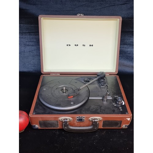 719 - A classic Bush portable turntable housed in a unique suitcase design. Bult-in speaker with stereo ou... 