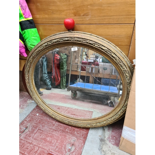 350 - An Antique oval mirror, featuring a richly detailed gilt frame, adding a touch of grandeur to any co... 