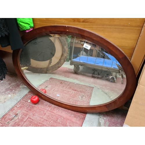 351 - Elegant mahogany-framed mirror, showcasing a rich patina and classic curvature, a statement piece fo... 