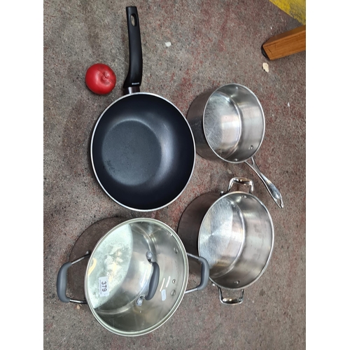 Robust kitchen ensemble featuring a non-stick frying pan and stainless steel pots with lids, catering to culinary versatility.
