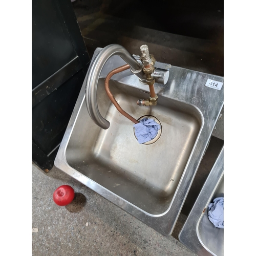 414 - A stainless steel sink, complete with a gracefully arched faucet,With all the necessary plumbing. Fr... 