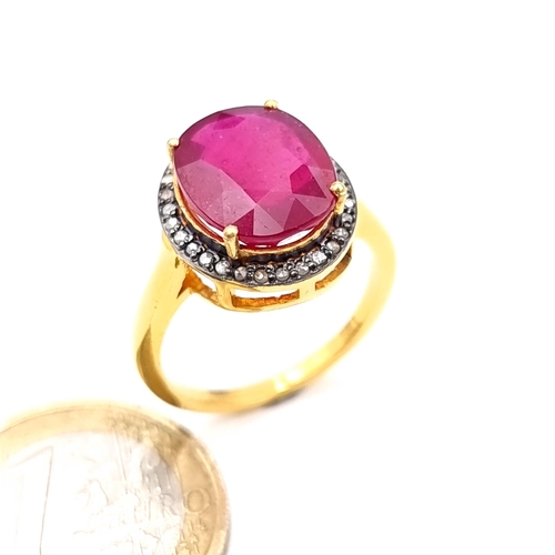 505 - Star Lot : A most attractive gold toned ruby set ring with a diamond surround, ruby is 6.8 cts, ring... 