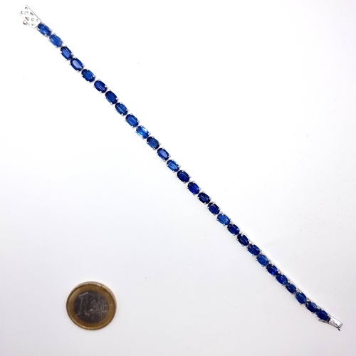 519 - A very nice example of a tennis style bracelet of 28 beautifully matched  sapphires, all set in Ster... 