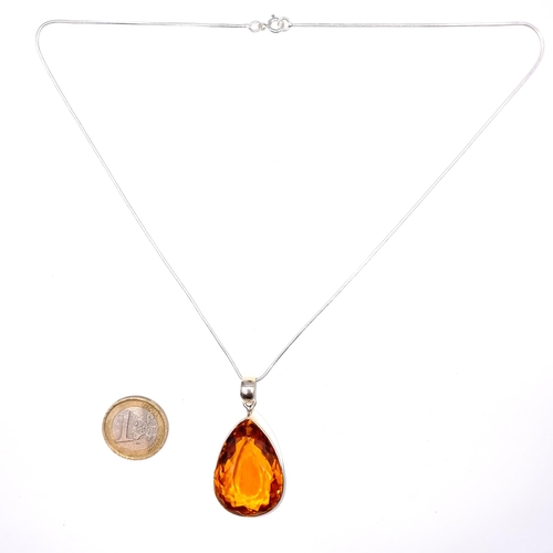 522 - An attractive tear drop facet cut orange topaz pendant and chain, length 44cm, weight 22.6 grams. Br... 