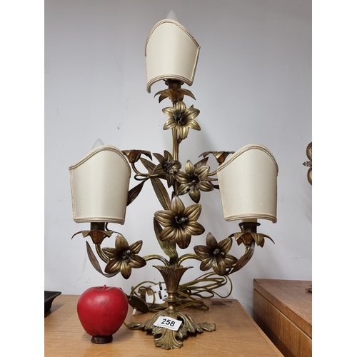 258 - A gorgeous brass three branch table lamp boasting beautiful floral detail throughout and 3 cream sha... 