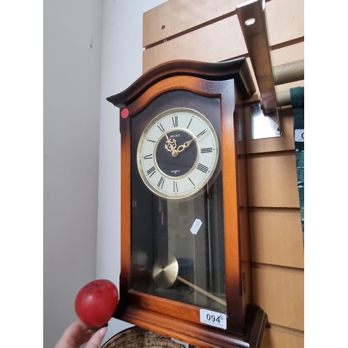 94 - A vintage Seiko quartz pendulum wall clock, held in a sunburst wooden frame.