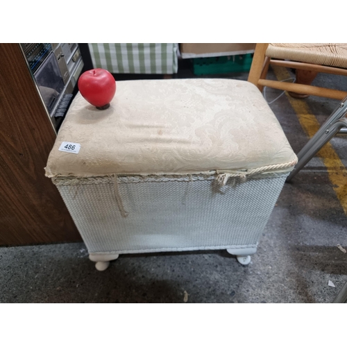 486 - A vintage padded ottoman stool with rattan construction and hinged lid.