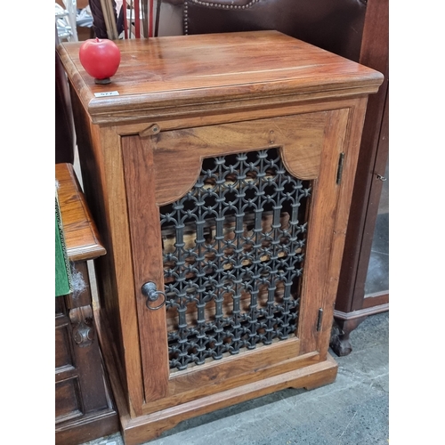 577 - A large handsome solid teak wine rack featuring space for twelve bottles and glasses behind a pierce... 