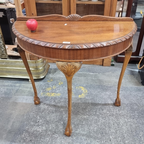 588 - A fabulous vintage demilune hall table boasting gallery back and ball and claw feet.