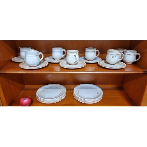 592 - A  22 piece art pottery  tea service, comprising of cups, saucers and plates. In a lovely cream and ... 