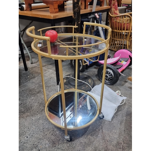 626 - A gorgeous two tiered hostess trolley with a brass toned skeleton, set on three wheels.