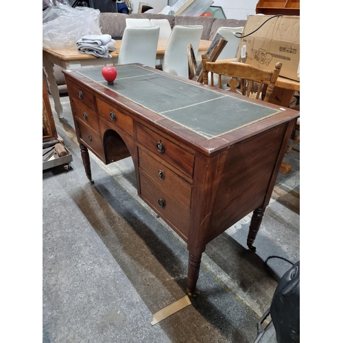 631 - Star Lot : A fantastic seven drawer antique desk with original green leather top and set on brass ca... 