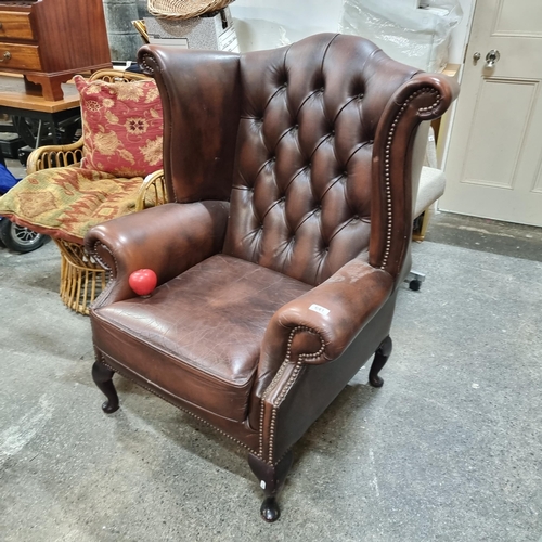 641 - Star lot : A quality English made leather wingback Chesterfield armchair. Features dark brown leathe... 