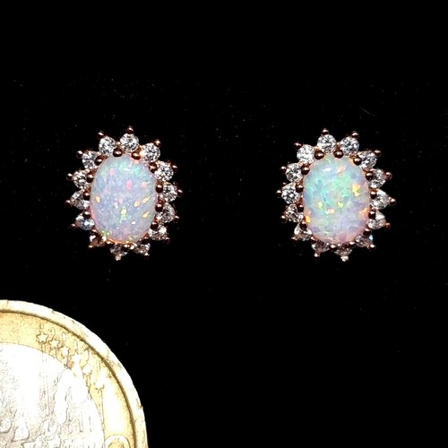 538 - A super pair of opal stone stud earrings set with gem stone surrounds. As new Boxed.